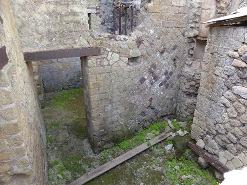 IV.19 Herculaneum, October 2014.
Looking south towards to doorway of room 6, rooms at rear of IV.19, photo taken from room 16 the triclinium of IV.4.
On the right side of this photo can be seen the wall at the rear of the latrine in the House of the Stags, next to it is
the latrine for IV.19 which would be in the corner near the piece of wood and bits of stones.
Above the latrine is a large pipe from the upper floor that discharged water into the drain well which was communal to both houses.
Photo courtesy of Michael Binns.